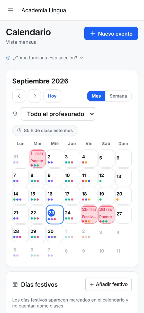 Calendario mensual del centro en el móvil, con un punto de color por clase en cada día y los festivos marcados.